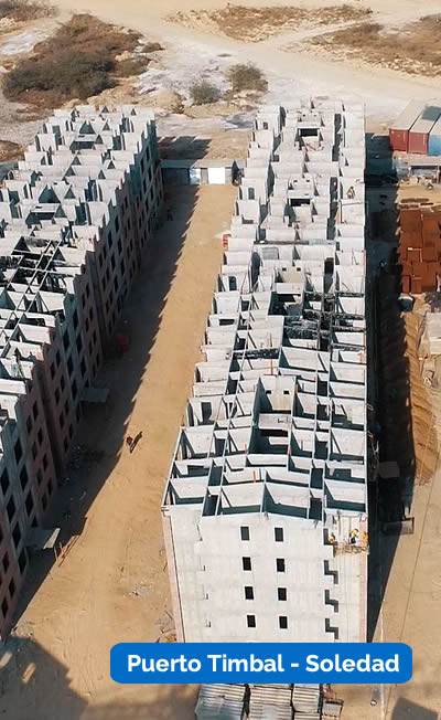 Vista aérea de dos edificios de hormigón de varios pisos sin terminar con materiales de construcción y equipos cerca. El texto dice "Puerto Timbal - Soledad.